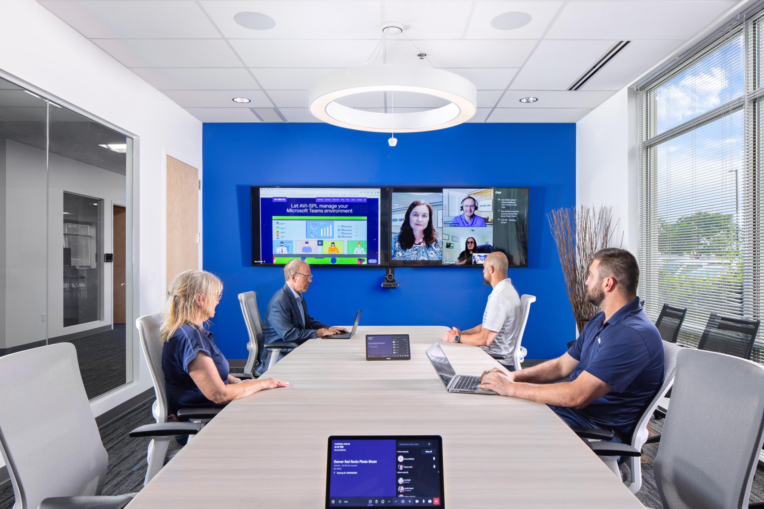 Five people meet in Signature Microsoft Teams Room and via a Teams meeting in a smart workplace.