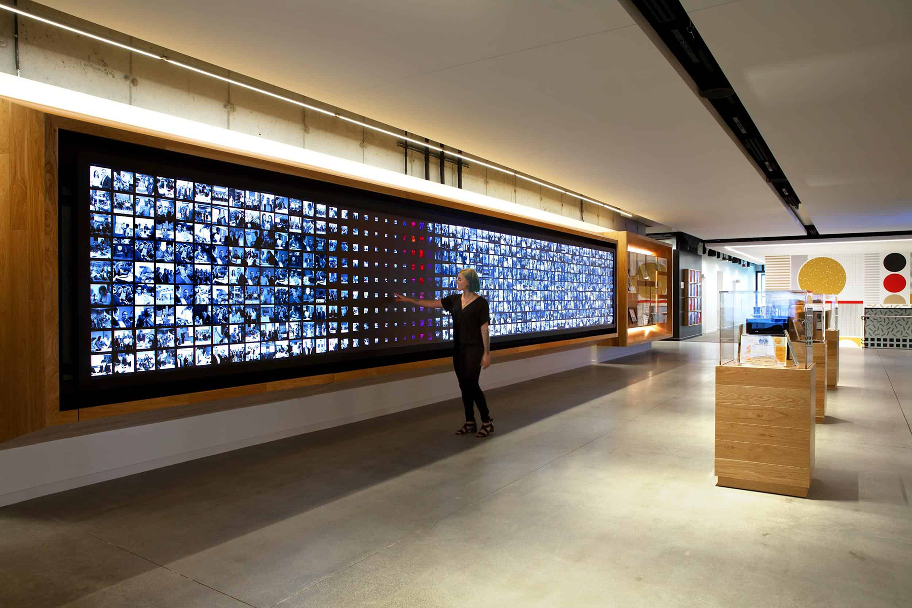 Woman touching large video wall in corporate lobby